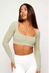 Top deportivo color verde claro, de manga larga y escote cuadrado.