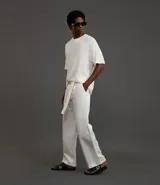Pantalón de vestir masculino, color blanco, de corte wide leg con pinzas y cinturón de lazo a juego.