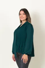 Blusa plisada de poliéster verde, con mangas largas, puño elástico y cuello en V con lazo.