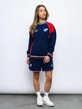 Buzo de felpa azul marino con mangas raglán rojas y detalles tricolor en puños, mangas y cuello. Incluye logo de Umbro bordado en el pecho y escudo del Club Nacional de Football.