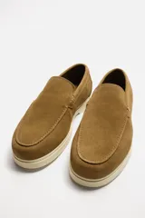 Mocasín casual de hombre color beige, fabricado en piel serraje, con corte liso, detalle de bordón y suela a contraste.