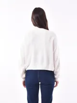 Polerón de tejido de punto color verde militar, con cuello alto y corte holgado.