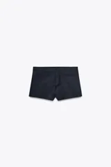 Shorts mini de tiro medio color azul marino. Cintura con trabillas, falsos bolsillos de vivo en delantero y cierre frontal con cremallera, botón interior y gancho metálico.