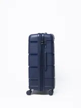 Valija rígida de viaje color azul marino con diseño de líneas horizontales. Cuenta con manija extensible, cuatro ruedas con giro de 360°, cierre con combinación numérica y organizadores internos.