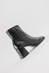 Botas cortas de cuero negro con cierre lateral y taco de madera.