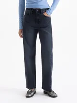 Jeans de denim con fit recto y tiro medio, en tonos grises azulados oscuros. El bajo es deshilachado.