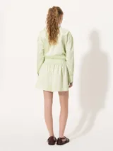 Short amarillo de tiro alto con pinzas delanteras y cierre invisible lateral.