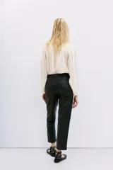 Pantalón de cuero ovino color dorado, de corte recto y largo al tobillo.