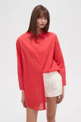 Camisa roja de algodón, corte holgado, con cuello clásico y cierre frontal con botones.