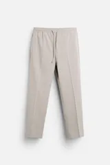 Pantalón de vestir color gris claro, corte recto, con cintura elástica ajustable con cordón, bolsillos laterales y traseros.