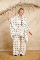 Pantalón palazzo color crudo con bordado de flores negras y cinto de la misma tela.