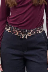 Cinto marrón con estampado de animal print, hebilla estándar y diseño ajustable.
