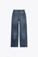 Pantalón de jean azul de corte wide leg, tiro alto y largo hasta el tobillo.