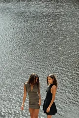 Vestido corto negro con cuello halter y sisas. Detalle de frunces en la falda. Cierre en la espalda con cremallera oculta.