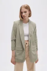Blazer color verde oliva, de corte entallado y mangas 3/4 con botón.