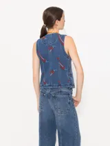 Chaleco denim azul con estampado de pimientos rojos, cuello redondo, pinzas de entalle, bolsillos sastreros y cierre frontal con broches.