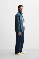 Pantalón azul marino de algodón con corte regular fit, bolsillos delanteros y traseros de vivo, cierre frontal con cremallera y botón.