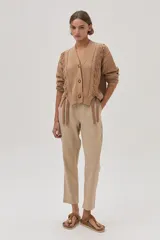 Pantalón chino de lino metalizado color beige, tiro medio-alto y pierna recta. Cuenta con bolsillos laterales y traseros.