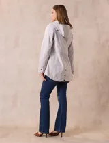 Campera impermeable color gris claro, marca Gallery. Tiene abertura central con cierre oculto y botones a presión, bolsillos delanteros y capucha plegable en el cuello.
