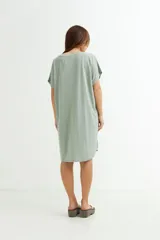 Vestido corto color verde oliva con estampado de dos rostros en color blanco.