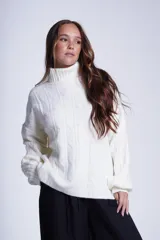 Sweater tejido color crudo con cuello alto y diseño de ochos.