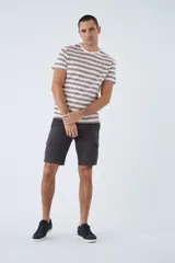 Remera de algodón a rayas horizontales en tonos blanco, marrón y rojo. Tiene cuello redondo, mangas cortas, corte regular y logo estampado en el pecho.