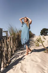 Vestido celeste de lino con mangas cortas y falda midi con volados de seda.