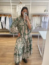 Vestido midi de viscosa azul con estampado floral beige, corte holgado, cuello camisero y mangas largas con puños acampanados.