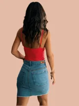 Minifalda de jean azul con bolsillos traseros y ruedo desflecado.