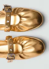 Zapato tipo bailarina color dorado, con punta redonda y tira sobre el empeine con hebilla metálica.