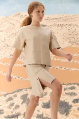 Top de cuero ovino color beige con corte moderno y mangas cortas.
