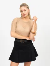 Falda short negra, de tiro alto, con corte acampanado y cierre lateral oculto en costura.