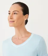 Remera de pijama celeste con escote en V y mangas cortas con ribete blanco.