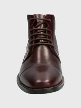 Bota de cuero color marrón con cordones, caña media y suela de goma.