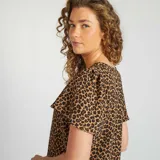 Blusa marrón con estampado animal print, escote en V y mangas cortas con volantes.