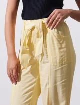 Pantalón de lino color amarillo con pretina ancha, pasadores y lazo de ajuste.