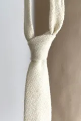 Corbata delgada de lana con forro interno y diseño a cuadros en tonos marrón y beige.