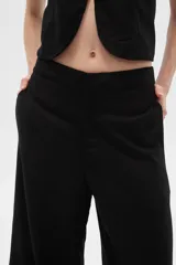 Pantalón negro ancho de lino y viscosa, de tiro alto y corte palazzo con aberturas en el ruedo.