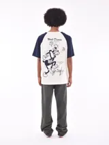 Remera de mangas cortas ranglan, color crudo con mangas azul marino y estampado frontal con la palabra "goofy" en cursiva.