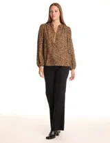 Blusa de gasa estampada con animal print, cuello a la base con escote en V y cierre dorado. Manga larga con puño elastizado.