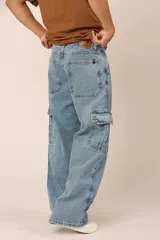Pantalón de jean celeste, corte holgado, con bolsillos cargo laterales y costuras frontales.