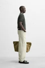 Jersey de punto color verde oliva, de calce relajado (relaxed fit), con cuello solapa y abertura frontal en forma de V. Es de manga corta y presenta acabados en rib en puños y ruedo.