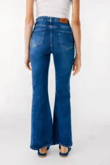 Pantalón de jean azul de corte acampanado con aberturas en el ruedo.