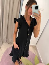 Vestido midi blanco con escote en V, abotonado al frente, mangas cortas con volados y falda evasé.