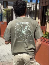 Camiseta verde militar de corte oversize con estampa en la espalda de una flor de hibisco y la frase 'Where hibiscus grows, peace flows'.