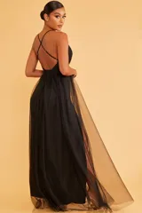 Vestido largo negro de fiesta con escote en V, breteles finos y falda con doble tajo lateral y sobrefalda de tul.