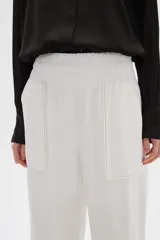 Pantalón blanco de viscosa, de corte recto y tiro alto, con bolsillos laterales y cintura elástica.