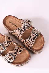 Sandalias con plataforma de corcho, con estampado animal print en tonos beige y negro, y hebillas metálicas plateadas.