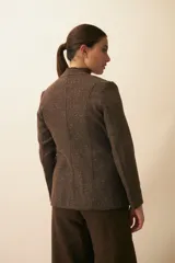 Chaqueta corta color beige, entallada, con escote en V, manga larga y cierre frontal con lazo fijo. Confeccionada en lana fina sin teñir, con bolsillos escondidos y terminaciones enviadas. Hecha 100% en Uruguay.