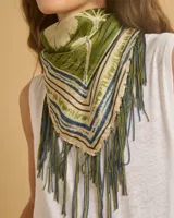 Pañuelo cuadrado de seda con estampado de motivos vegetales en tonos verde, beige, azul y marrón. Tiene flecos en los bordes.
